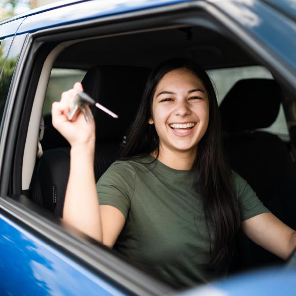 Image of young woman holding car keys and smiling